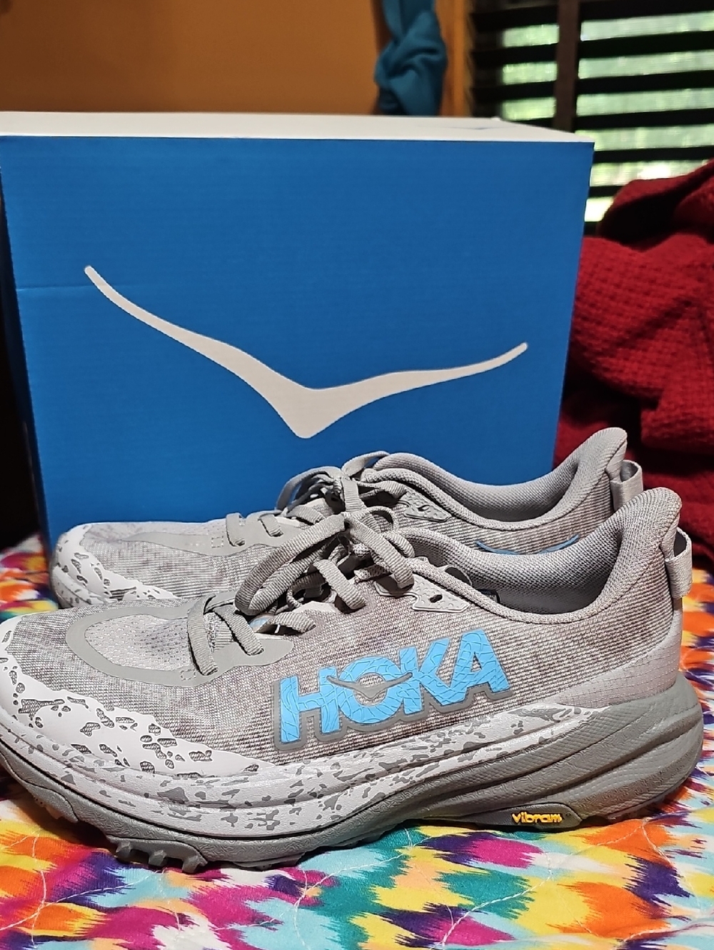 Hoka Gray Trail Running Shoes with Light Blue Logo.